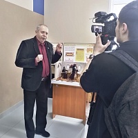 Ю.Ю. Леснвеский дает интервью рядом с экспозицией.