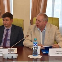 Директор библиотеки Ю.Ю. Лесневский за столом вместе с Е.А. Рукавишниковым