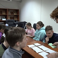 Школьники принимают участие в деловой коммуникационной игре «Grator». Жанна Булгакова раскладывает игровые карточки.