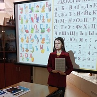 Юлия Гайнуллина, сотрудник отдела обслуживания читателей демонстрирует прибор и азбуку Шрифта Брайля