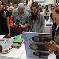 Посетители площадки НОСБ с интересом изучают многоформатное пособие и фотографируют макет здания Новосибирского областного театра кукол