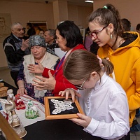 Посетители выставки у экспозиции, посвященной вологодскому и михайловскому кружеву