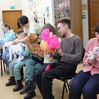 Участники мероприятия тактильно исследую куклы, принесенные артистами-кукловодами из Новосибирского театра кукол