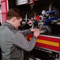 Школьник исследует устройство пожарной машины в музее пожарно-спасательной службы Новосибирской области.