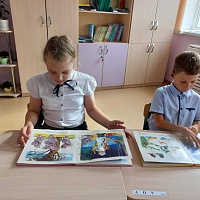 Ученики школы рассматривают книги с произведениями К.И. Чуковского.