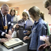 Сотрудник ГБУК НОСБ А.Б. Ковалев демонстрирует посетителям тактильный макет «Средневековая книга»