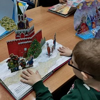 Воспитанник детского сада тактильно-исследует книгу «Гимн России в детских рисунках»