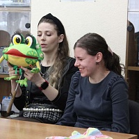Читательницы библиотеки Анастасия Лобастова и Светлана Лапацкая рассматривают куклу лягушки