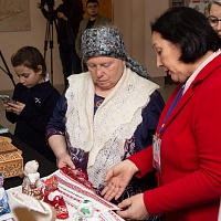 Л.М. Байгулова демонстрирует читательнице ГБУК НОСБ образец рушника, обрамленного михайловским кружевом