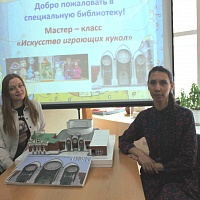 Артисты-кукловоды Алина Романенко и Дарья Савина с макетом и многоформатным изданием, посвященным новосибирскому театру кукол.