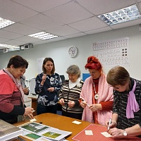 Участницы мероприятия в отделе реформатирования и специальной полиграфии изготавливают сувениры - тактильные закладки